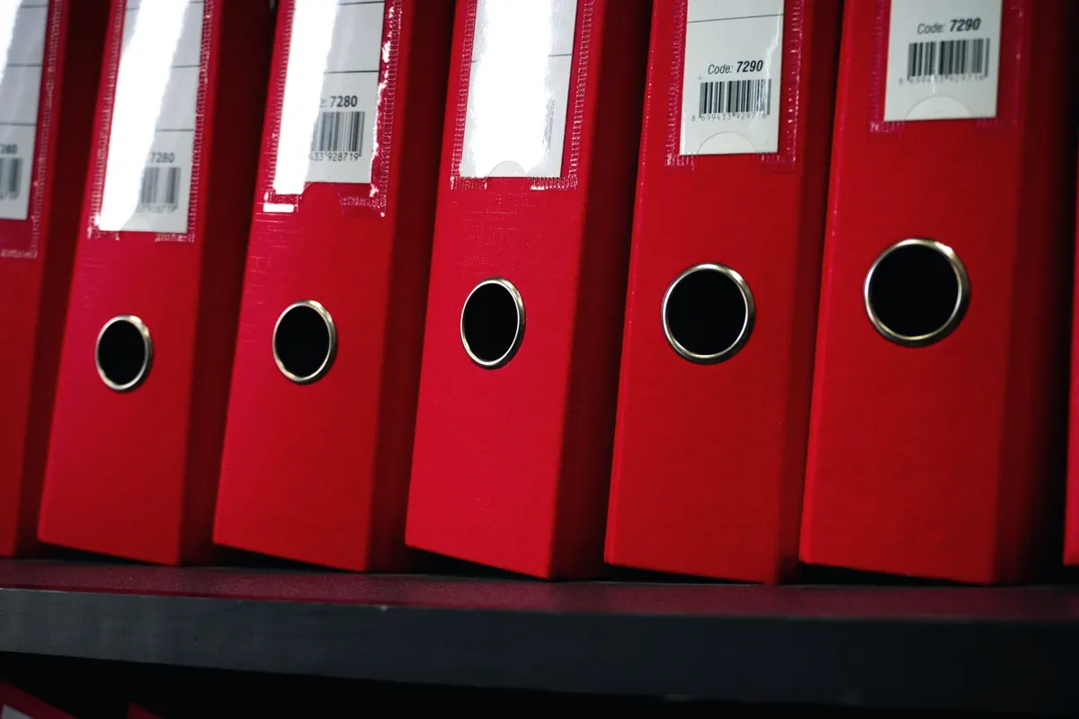 Archivadores ordenados en una estantería de oficina